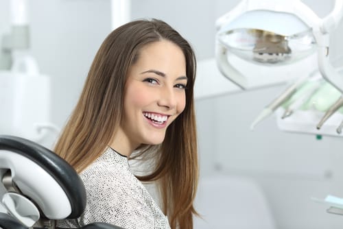 Smiling Patient On Dentist Chair